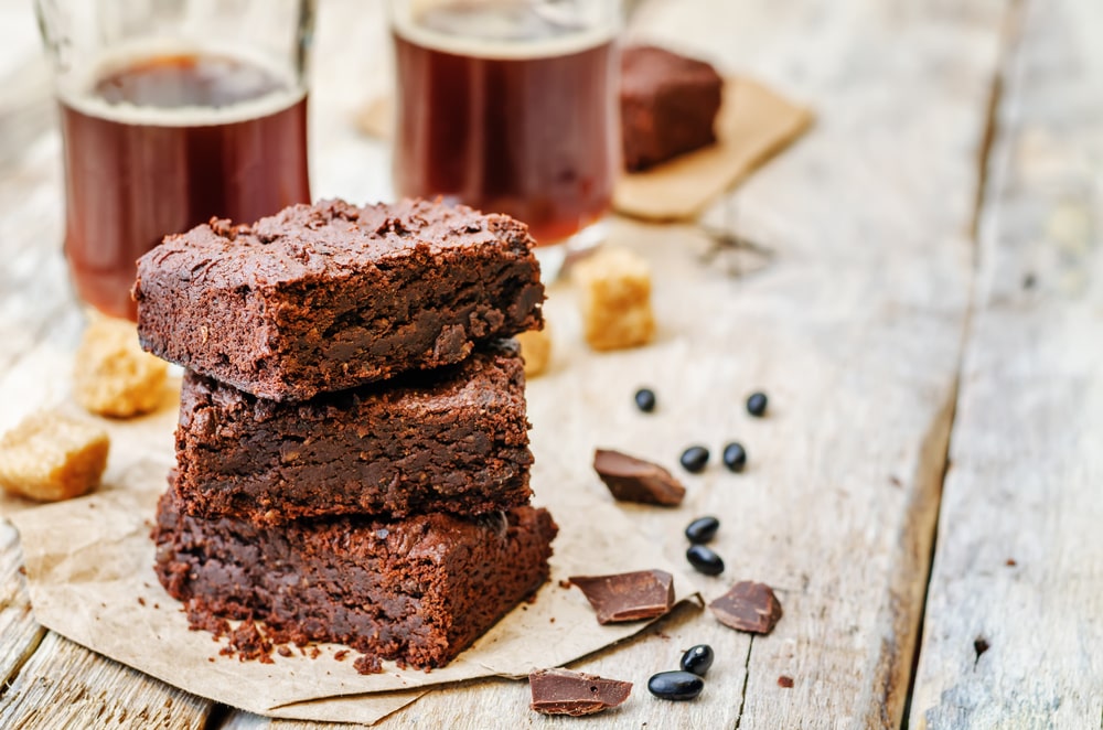 Tři dílky čokoládových brownies z černých fazolí na dřevěném podkladu